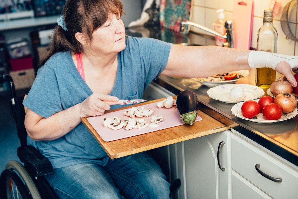 Kvinna i rullstol lagar mat